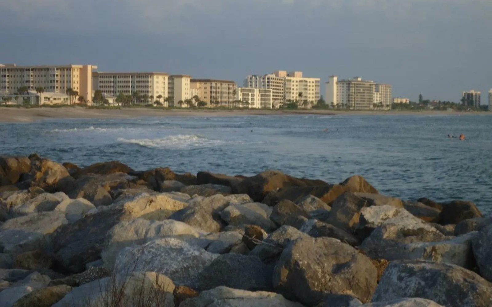 Beach community boardwalk with palm trees and ocean view